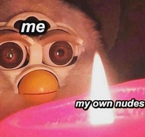 A Furby staring intently at the flame on a hot pink candle. Text on Furby's head reads "me". Text on the candle reads "my own nudes."