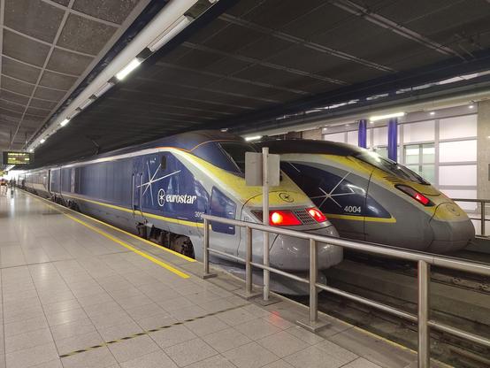 Foto: ein alter und ein neuer Eurostar in einem oben geschlossenen Bahnhof.
