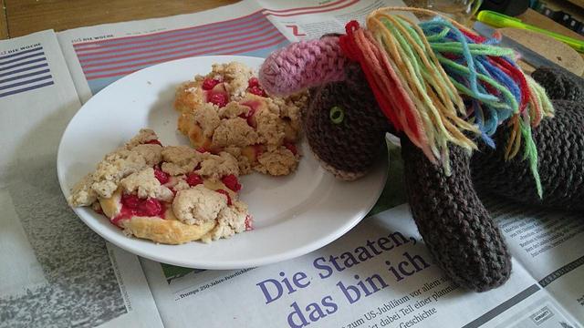 Max, das bunte Strickhorn, mit zwei Johannisbeerkeksen.
