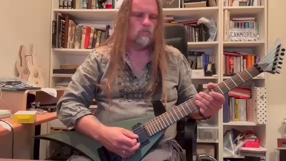 A long hair metal head in Ukrainian military vyshyvanka plays the guitar