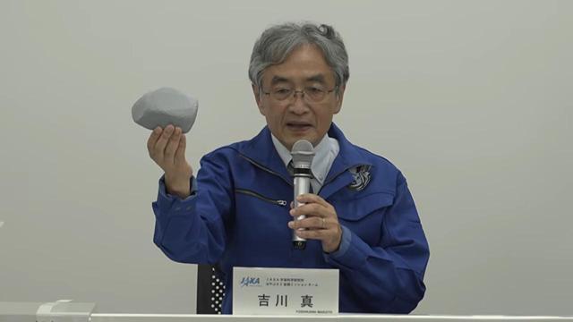 Screenshot of Professor Yoshikawa holding a ... fairly shapeless... grey model.