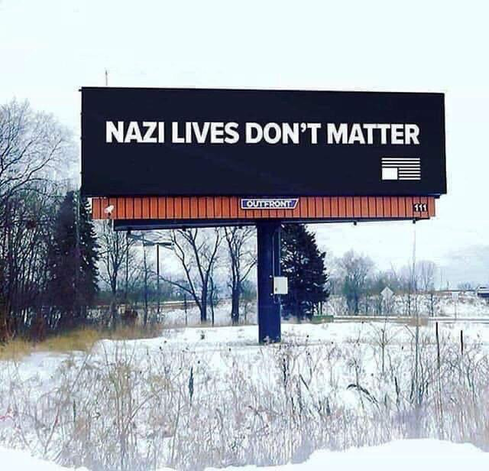 A large billboard with a plain black background and white text that reads, “NAZI LIVES DON’T MATTER”