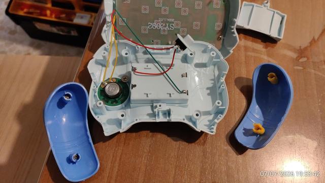 Interior de un juguete de plástico tipo mando. Se ve además el altavoz y la parte trasera de la pcb de los botones.