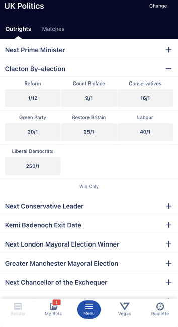 A screenshot of a mobile betting application interface displaying various UK political markets. The Clacton By-election section is expanded, listing odds for several parties and candidates including Reform, Count Binface, and the Conservatives. Binface is 9/1, Reform is 1/12.