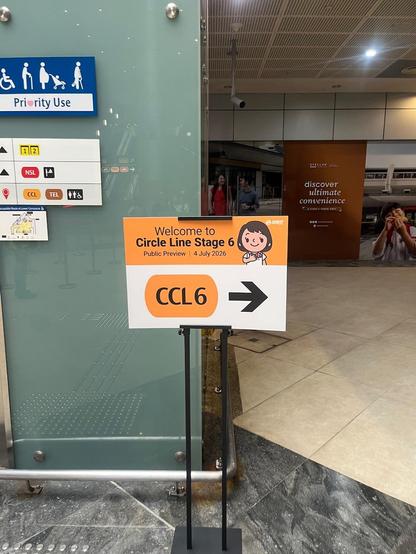 Transit station sign for “Welcome to Circle Line Stage 6” with a right arrow, near priority-use and station direction signs.