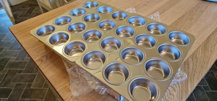 Two stainless steel bun trays, each with 12 insets.