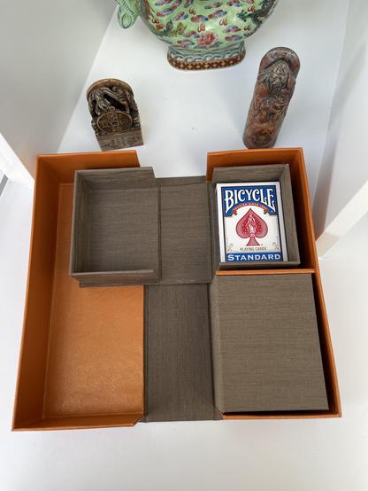 A brown and orange folding box for storing playing cards
