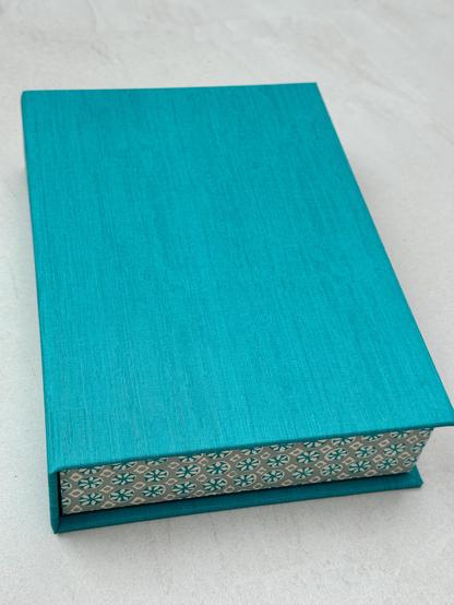 A turquoise box with Japanese geometric patterned paper covering the sides