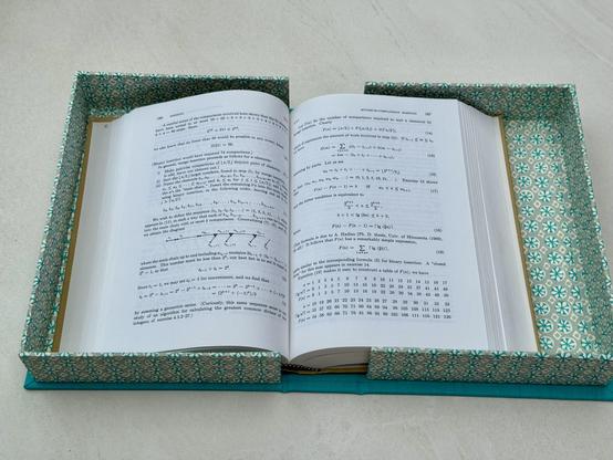 A turquoise box opens to show a book that was stored inside