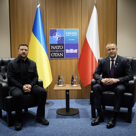 Zelensky and Nawrocki sitting together at with Ukraine and Poland national flags behind them