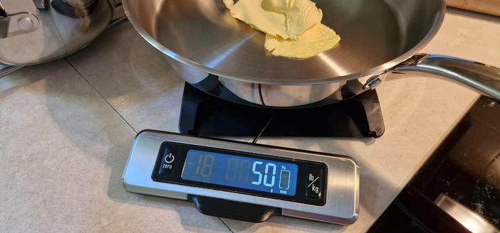 A set of Oxo scales with the screen pulled forward while a bit frying pan is on the weigher bit.