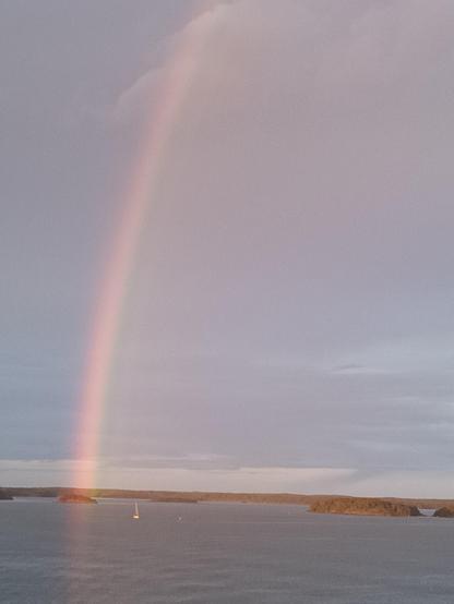 Aufnahme mit dem Standardobjektiv bei maximaler Zoomstufe (Digitalzoom) auf das Ende des Regenbogens. Neben dem Ende des Regenbogens fährt eine Segelyacht unter Segel. Das Bild hat keinen so tief im Kontrast stehenden Himmel wie die vorherigen.
