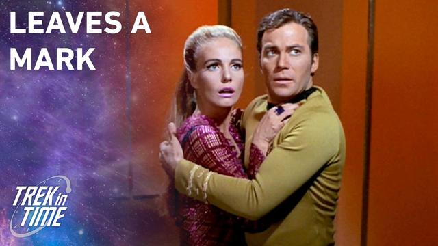 Kirk holding Odona as they both look off-screen in fear