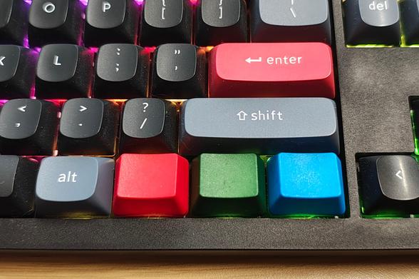 A close up of the keys to the right of the space bar on a Keychron keyboard. 3 of the modifier keys have been replaced by red, green and blue keys.