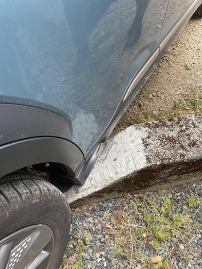 back passenger side corner near the tire is crunched into the black plastic on the cement