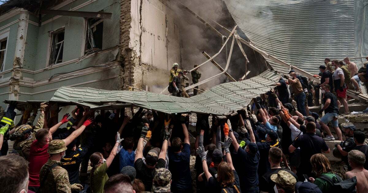 Workers remove debris from a destroyed hospital