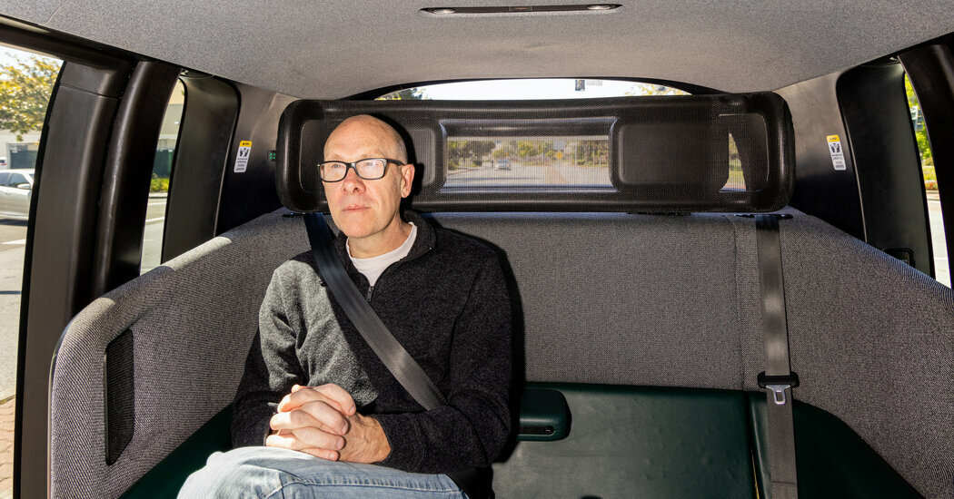 The New York Times reporter Cade Metz riding in a Zoox robot taxi in Foster City, Calif.