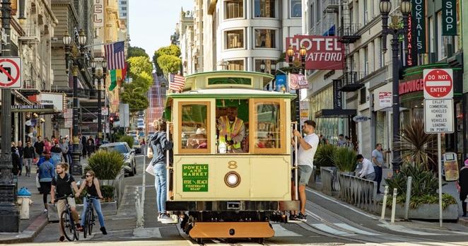 Eine historische Cable Car fährt in San Francisco einen Hügel herunter.
