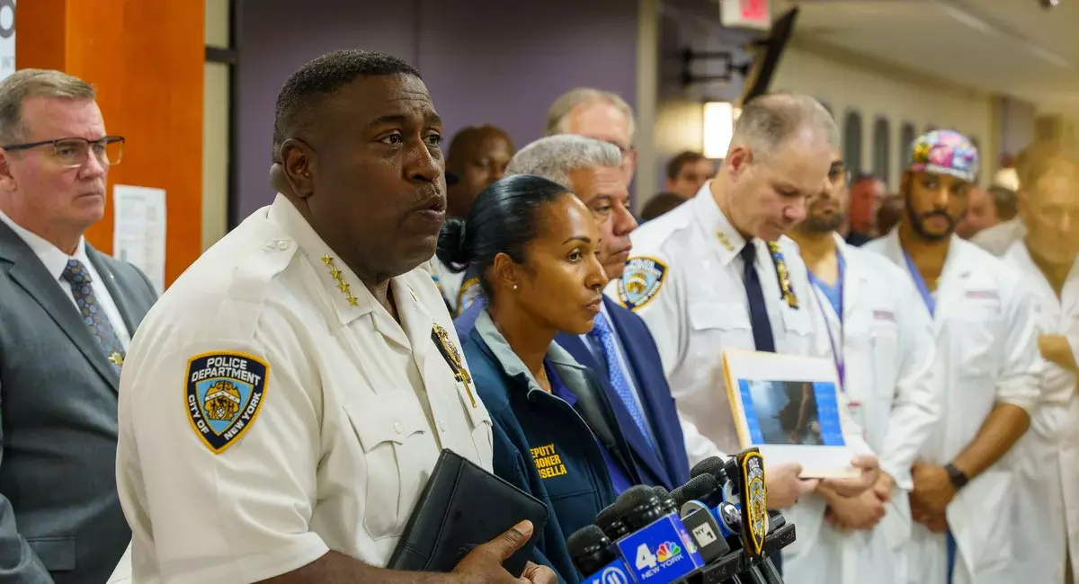 Police officers brief the media after visiting an officer who was shot in the 73rd Precinct on Sunday.