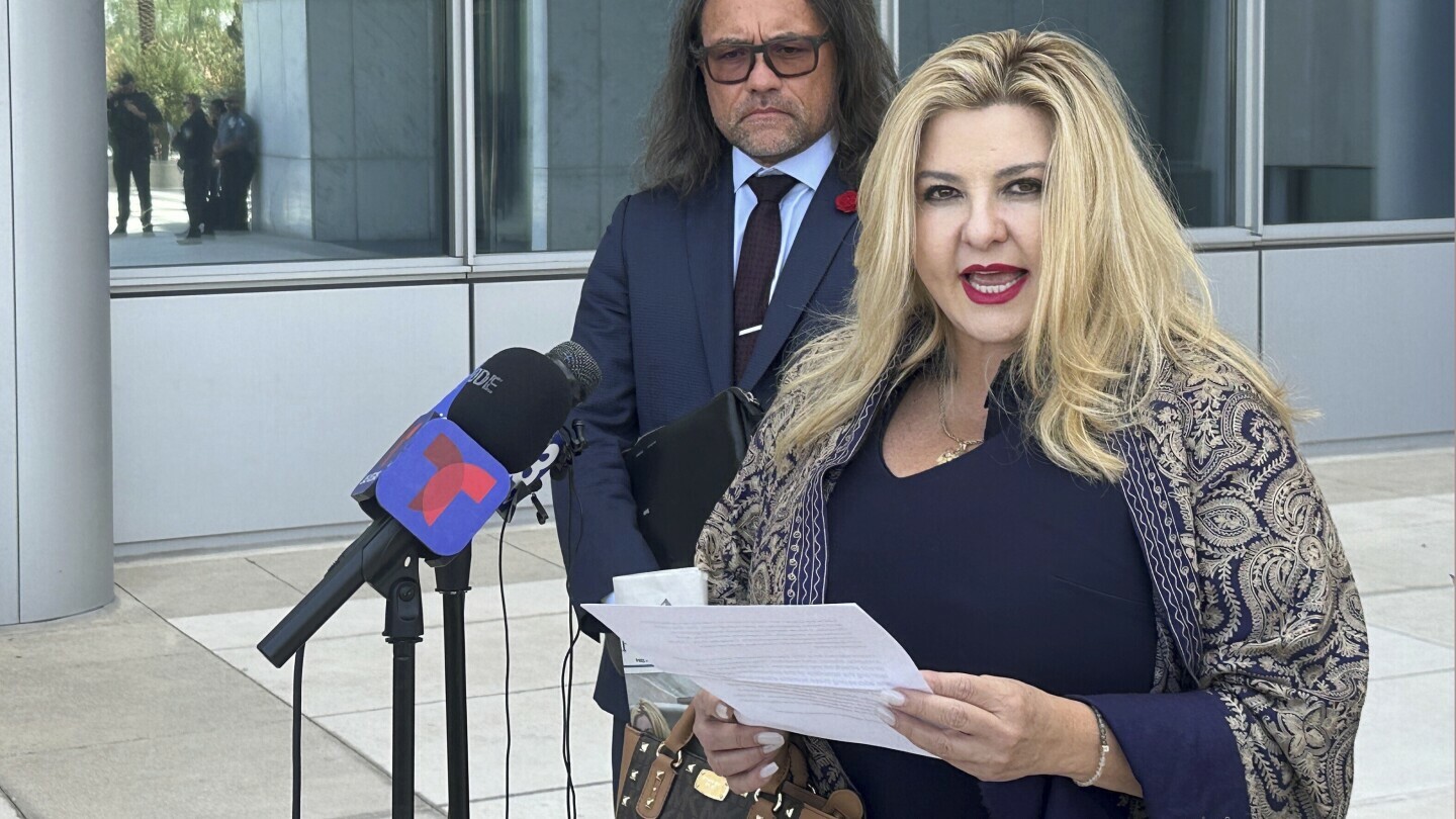 FILE - Michele Fiore, a Pahrump, Nev., judge who ran unsuccessfully for state treasurer in 2022, speaks to reporters outside U.S. District Court in Las Vegas on Friday, July 19, 2024, after pleading not guilty to federal fraud and conspiracy charges. Her attorney, Michael Sanft, watches at left. Fiore who ran unsuccessfully two years ago for state treasurer was found guilty Thursday, Oct. 3, 2024 of using funds raised for a statue honoring a slain police officer for political and personal costs, including plastic surgery.(AP Photo/Ken Ritter, File)