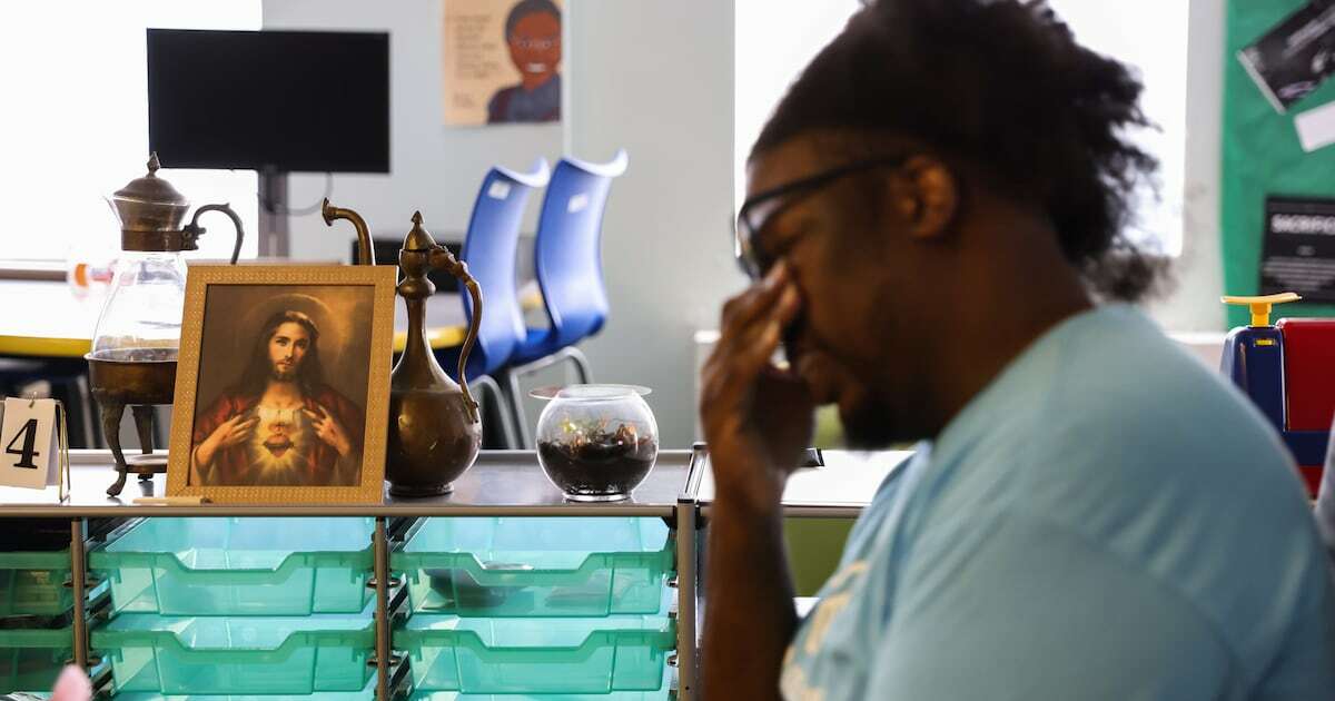A man is pictured in a classroom at a Catholic school.