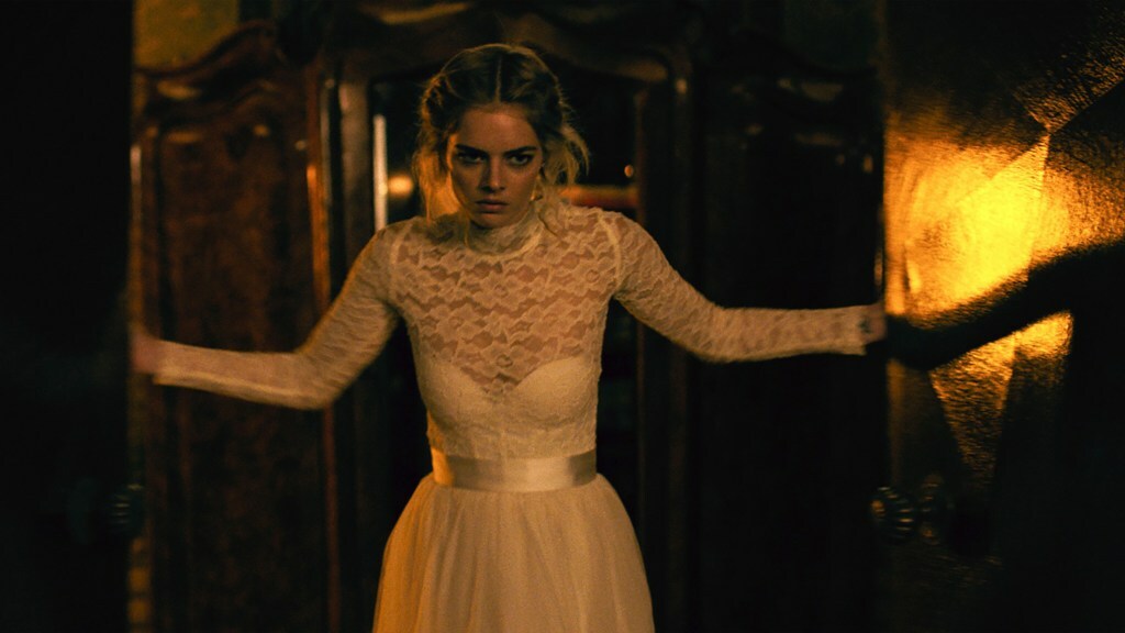 Samara Weaving wears a wedding dress and stands in a double doorway in a still from 'Ready or Not'
