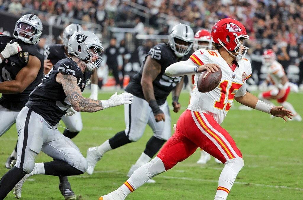 Patrick Mahomes #15 of the Kansas City Chiefs is chased by Maxx Crosby #98 of the Las Vegas Raiders in the third quarter of their game at Allegiant Stadium on October 27, 2024 in Las Vegas, Nevada.