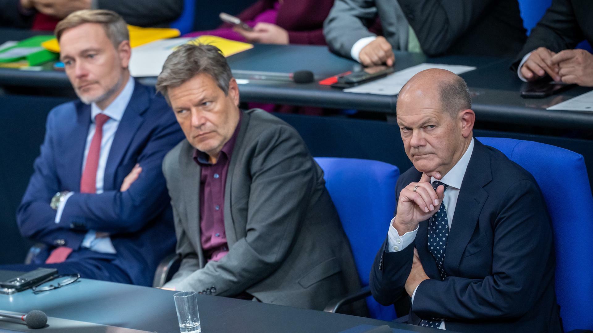 Bundeskanzler Olaf Scholz,  Robert Habeck und Bundesminister Christian Lindner sitzten vor dem Ampelaus zusammen im Bundestag. 