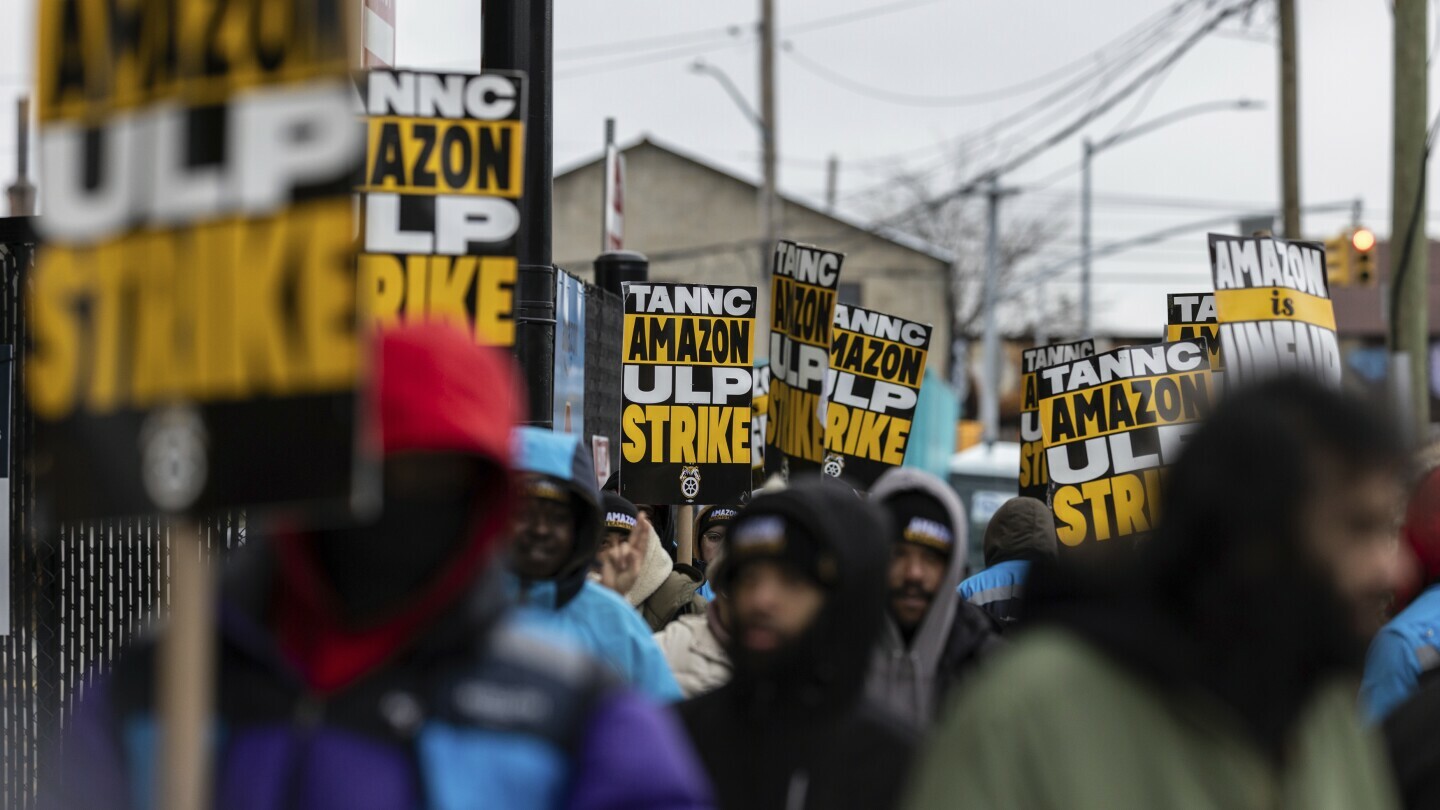 Amazon workers and members of the International Brotherhood of Teamsters picket in front of the Amazon fulfilment center in the Queens borough of in New York, on Friday, Dec. 20, 2024. (AP Photo/Stefan Jeremiah)