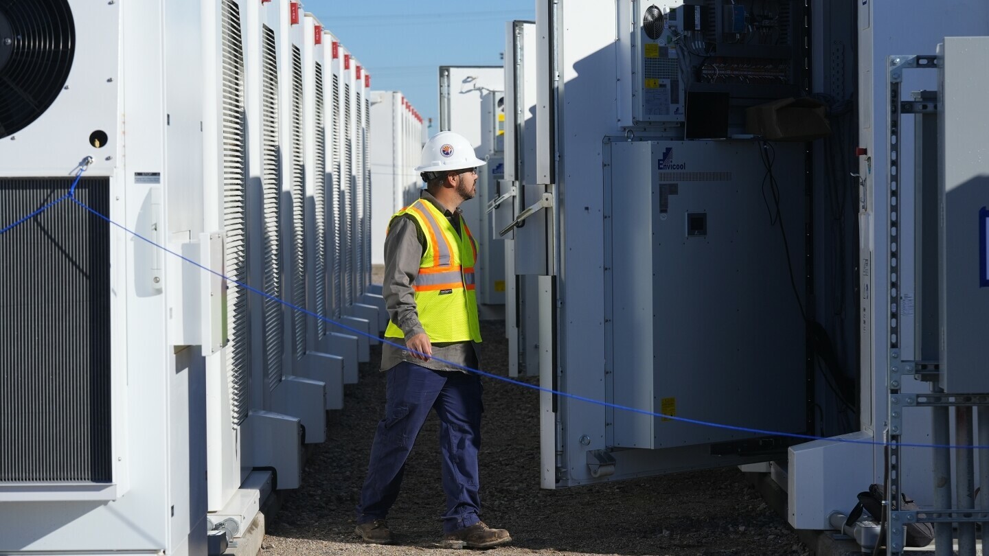 A worker does checks on battery storage pods at Orsted's Eleven Mile Solar Center lithium-ion battery storage energy facility, Feb. 29, 2024, in Coolidge, Ariz. (AP Photo/Ross D. Franklin, File)