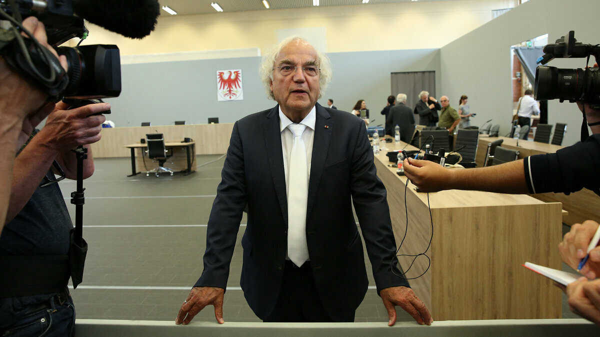 Thomas Walther steht vor Kameras in einem Gerichtssaal