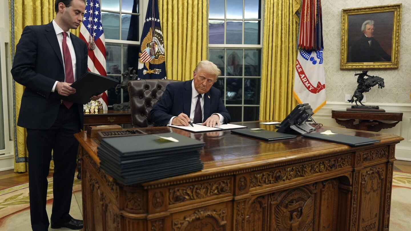 President Donald Trump signs an executive order withdrawing the U.S. from the World Health Organization in the Oval Office of the White House, Monday, Jan. 20, 2025, in Washington. (AP Photo/Evan Vucci)