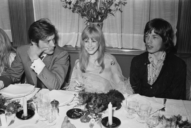 French actor Alain Delon, English singer and actress Marianne Faithfull, and English singer Mick Jagger at a meeting with film director Jack Cardiff to discuss his film 'The Girl on a Motorcycle', 1967. (Photo by Express/Hulton Archive/Getty Images)