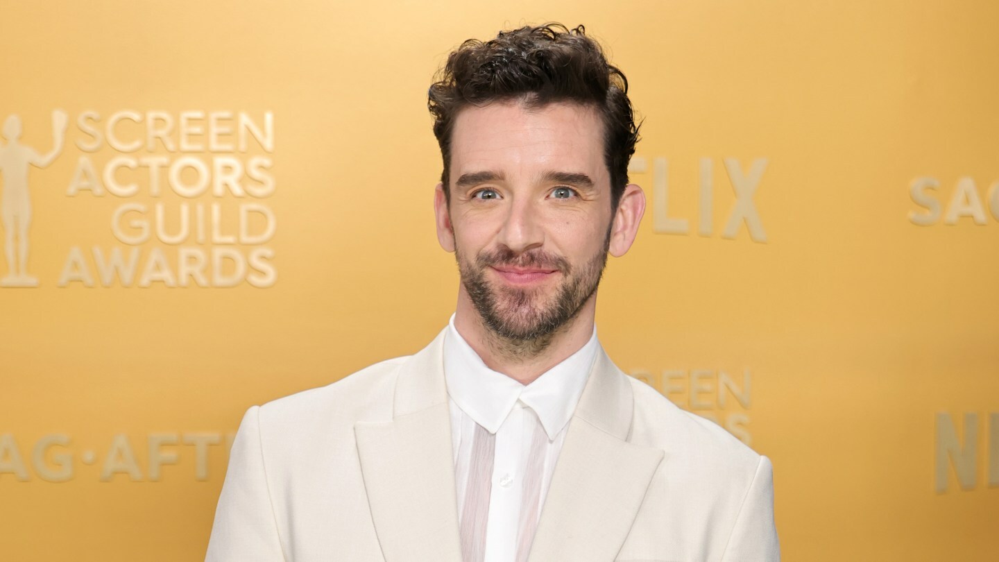 Michael Urie attends the SAG Awards and poses in a white sparkly suit.