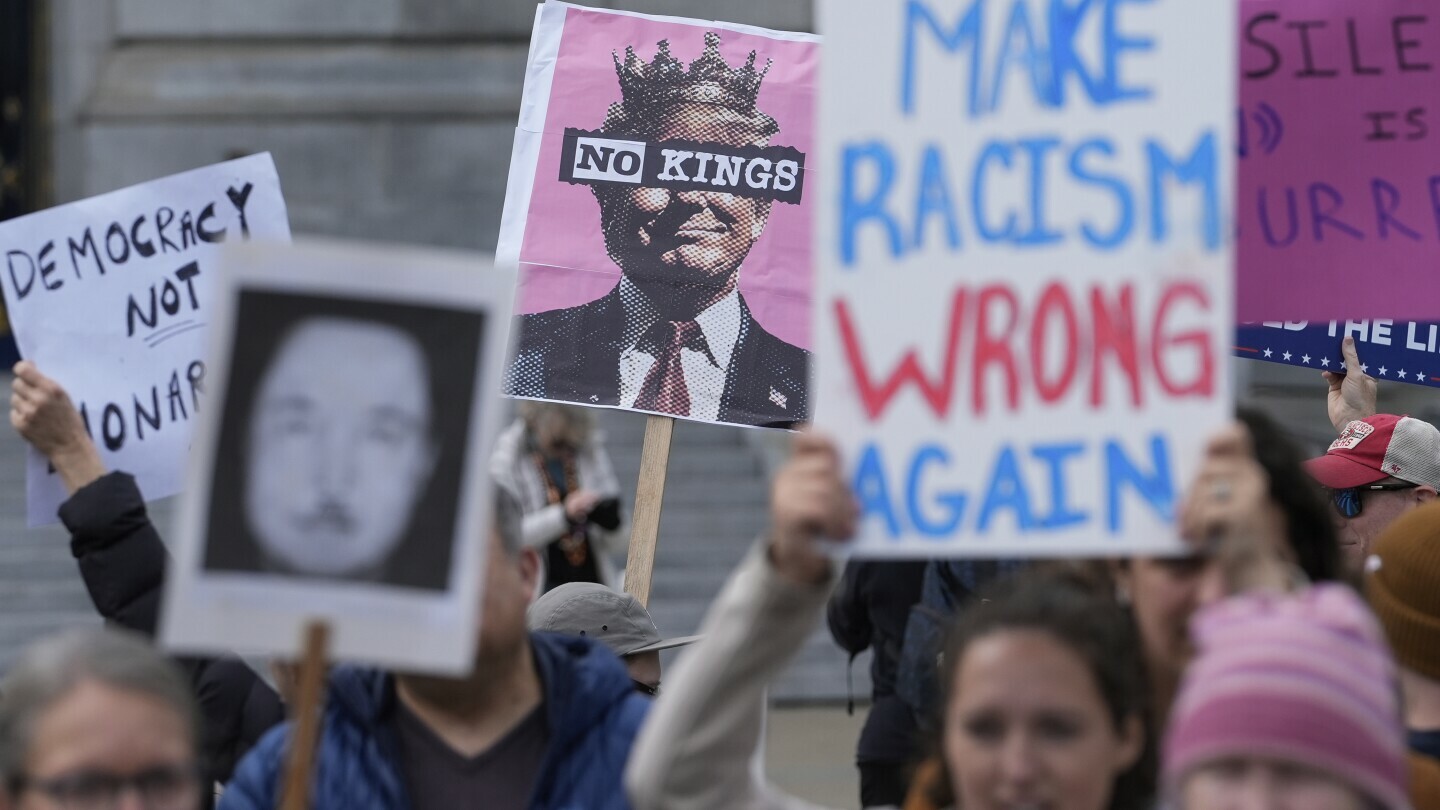 People hold up signs to protest the Trump administration Tuesday, March 4, 2025, in San Francisco. (AP Photo/Godofredo A. Vásquez)