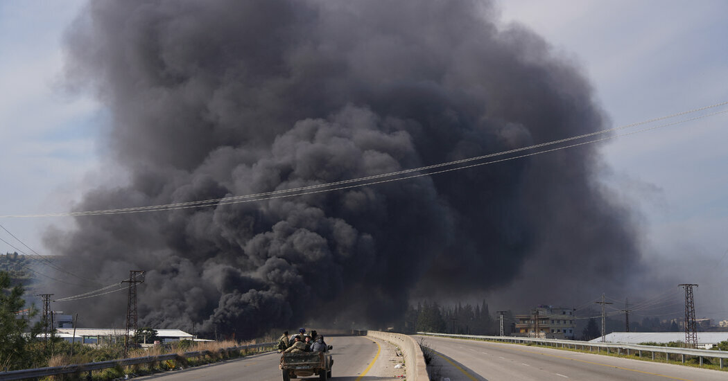 Smoke rising near a road in Latakia, Syria, on Friday, amid clashes between Syrian security forces and fighters loyal to former President Bashar al-Assad.