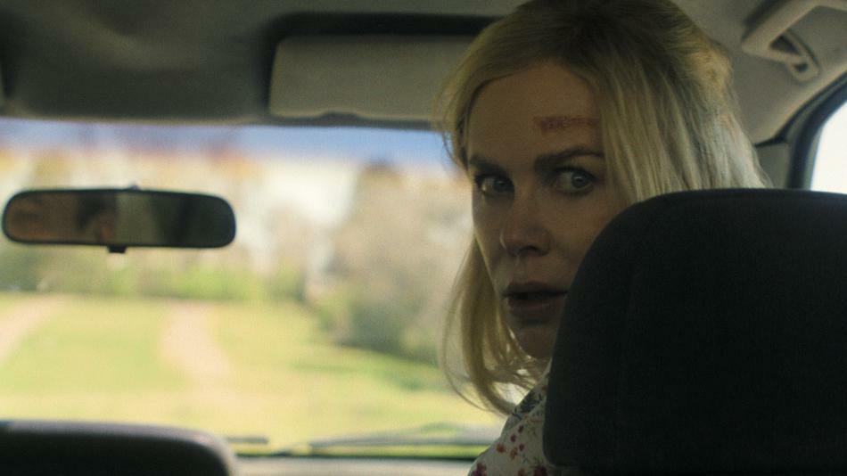 Nicole Kidman looks over her shoulder in the front seat of a car with a bruise on her forehead in a still from 'Holland'.