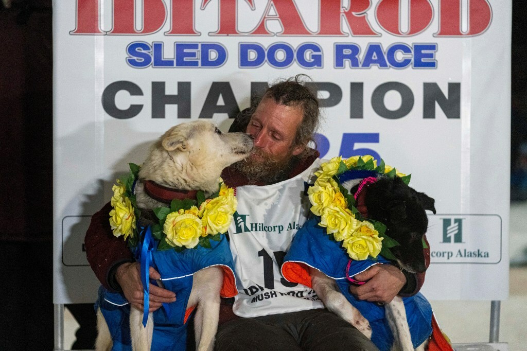 Jessie Holmes hugs his lead dogs Polar, left, and Hercules after winning the Iditarod Trail Sled Dog Race early Friday morning, March 14, 2025 in Nome, Alaska