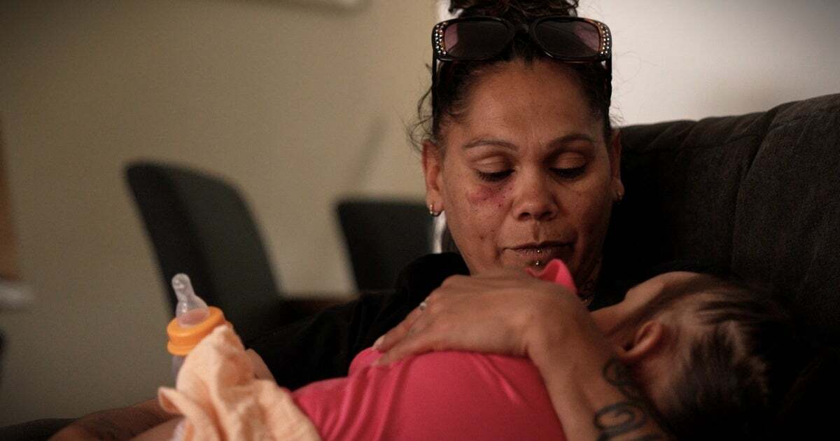 A woman cradles a toddler
