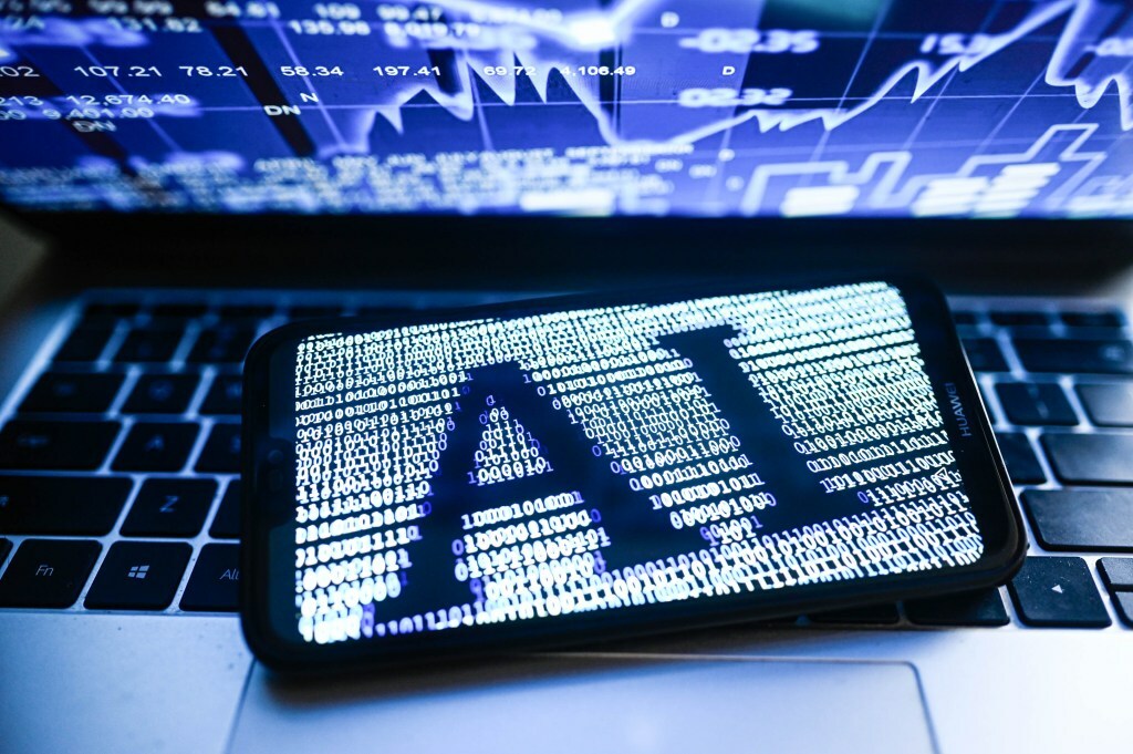 illustration an Artificial Intelligence (AI) symbol is displayed on a smartphone with stock market percentages in the background