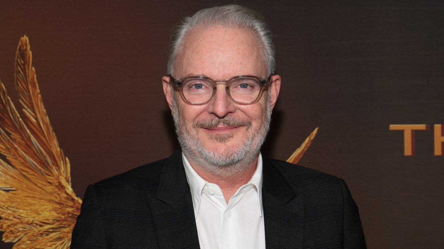 Francis Lawrence poses in glasses against a brown backdrop.