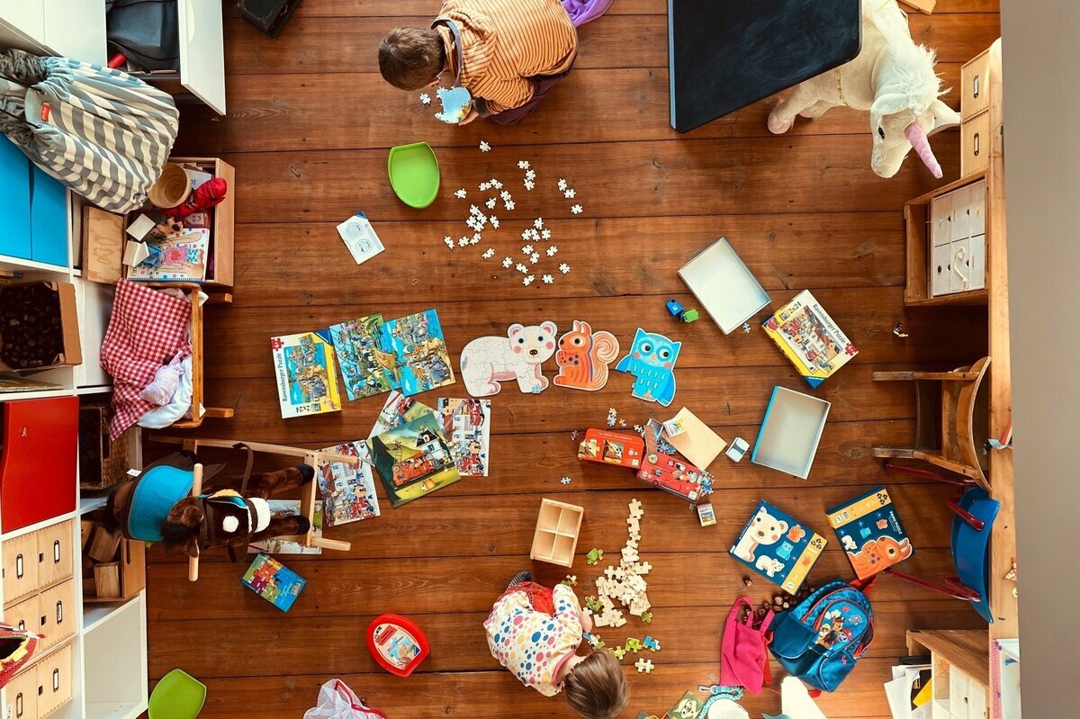 Blick von oben in eine Kinderzimmer, der Boden voller Spielsachen