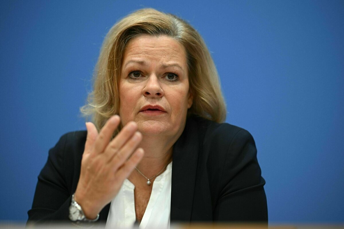 Eine Frau schaut ernst und macht eine Geste mit ihrer rechten Hand