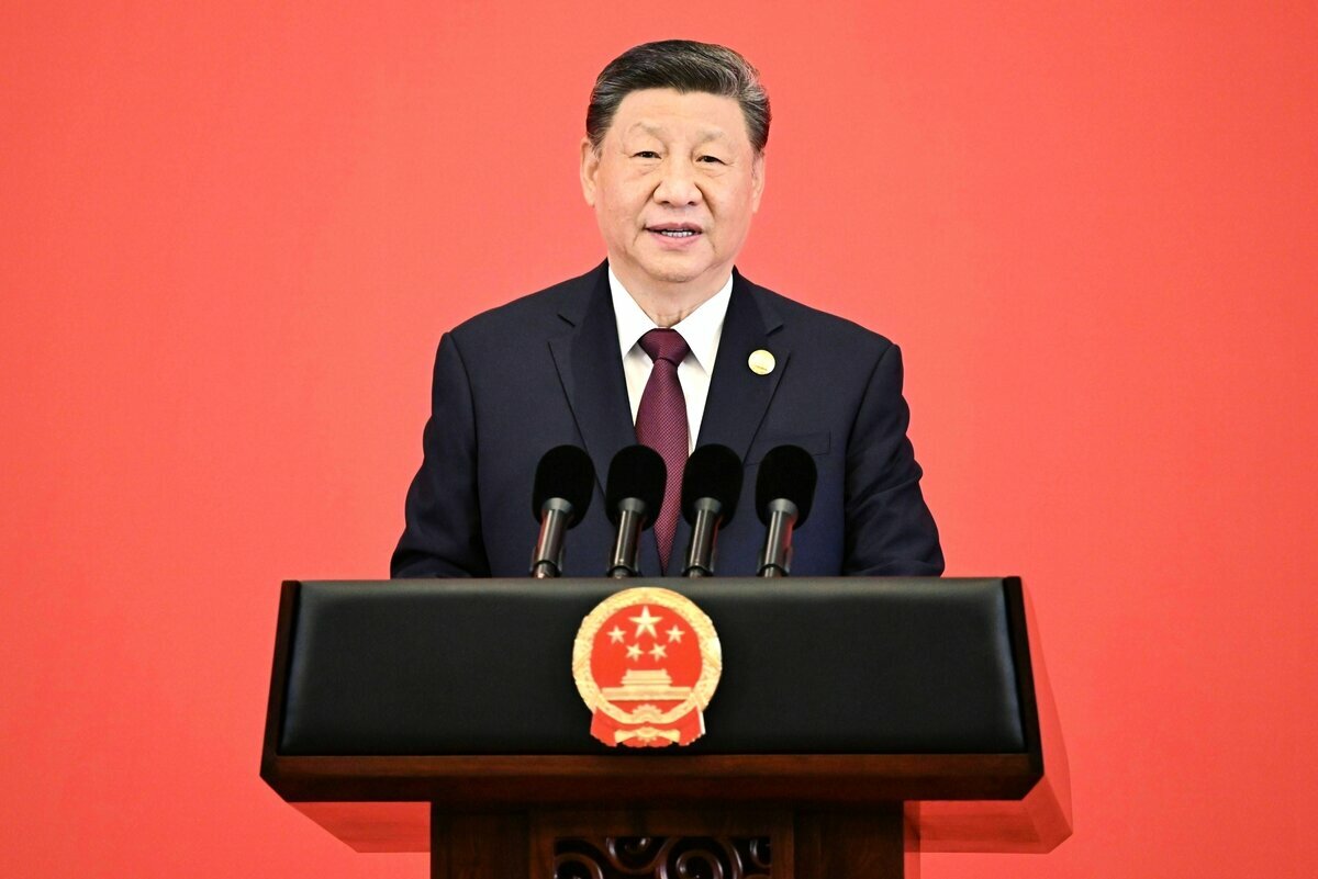 Xi Jinping spricht an einem Rednerpult vor einer roten Wand