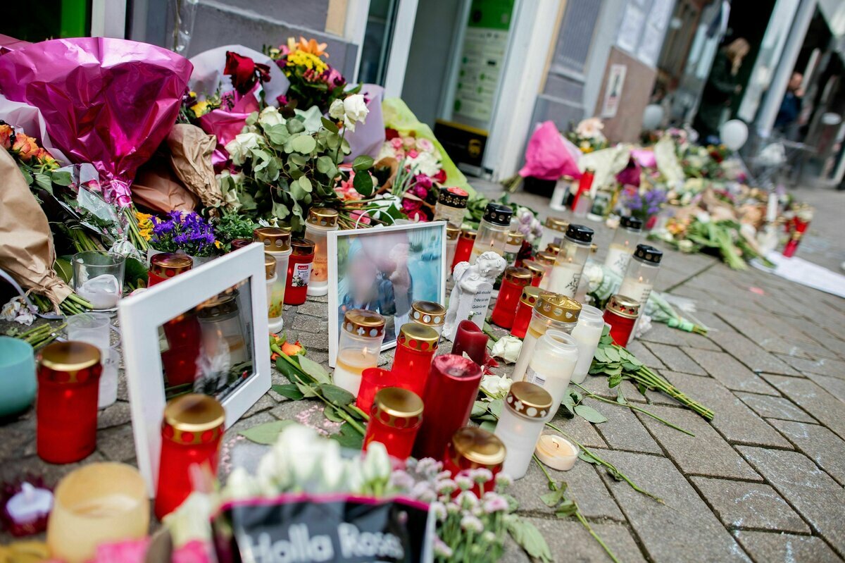 Zahlreiche Blumen und Kerzen stehen in der Innenstadt an einer Hauswand