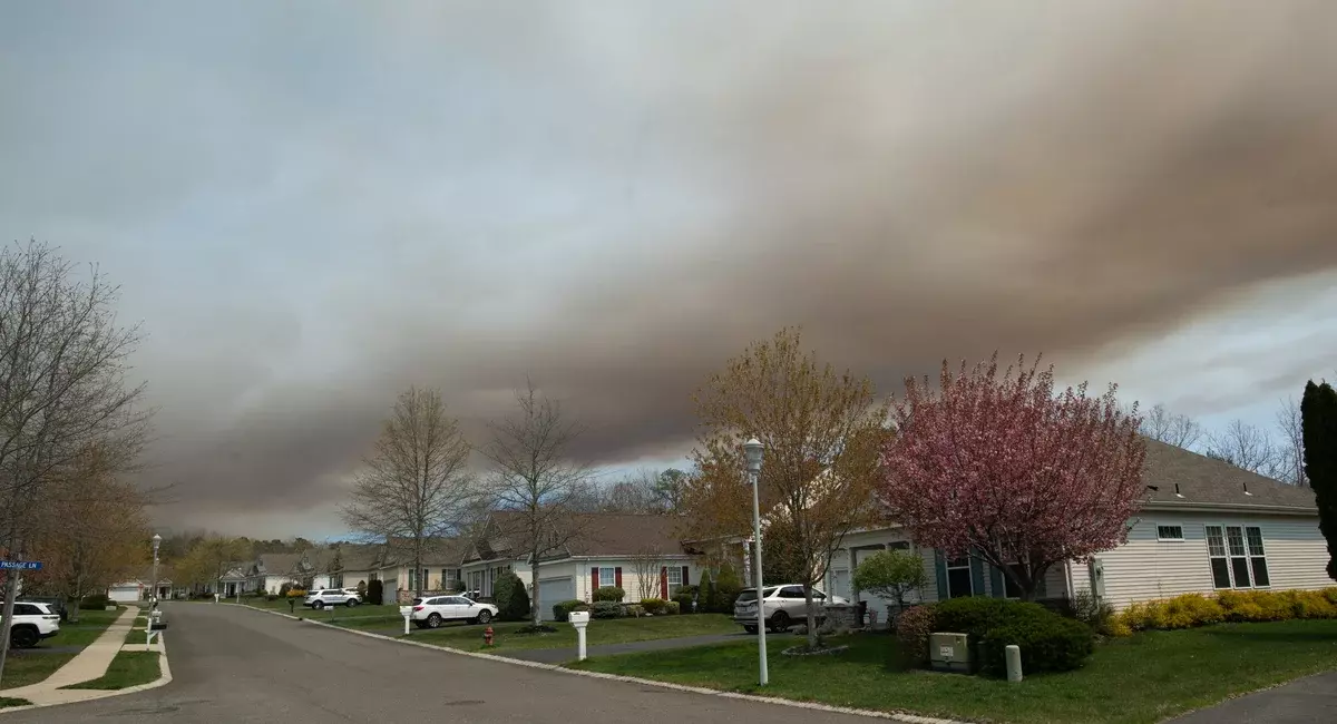 Smoke from the Jones Road Fire is seen over homes in a neighborhood in Ocean County, New Jersey, on April 23, 2025.