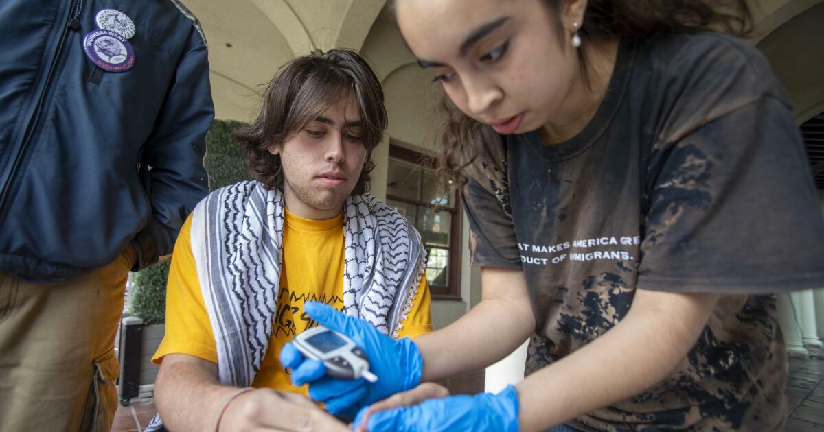 Los Angeles, CA - April 25: Student Evan Zeltzer, left, has his vitals checked by during a hunger strike at Occidental College on Friday, April 25, 2025, in Los Angeles, CA. (Hon Wing Chiu / For The Los Angeles Times). A group of 10 students are participating in a hunger strike at Occidental College as they call on their college to divest from weapon-making companies as the war in Gaza continues. They're also calling on their college to provide more protections for international students, who have increasingly seen their visas revoked under the Trump administration. The students started their hunger strike on Monday, April 21.
