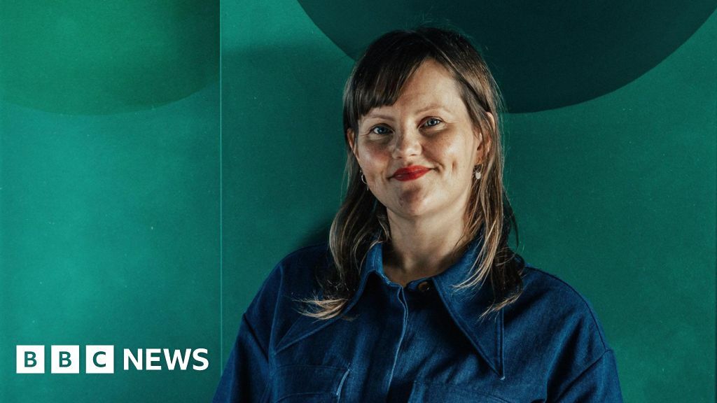 Sabine Zetteler in a blue shirt against a green background