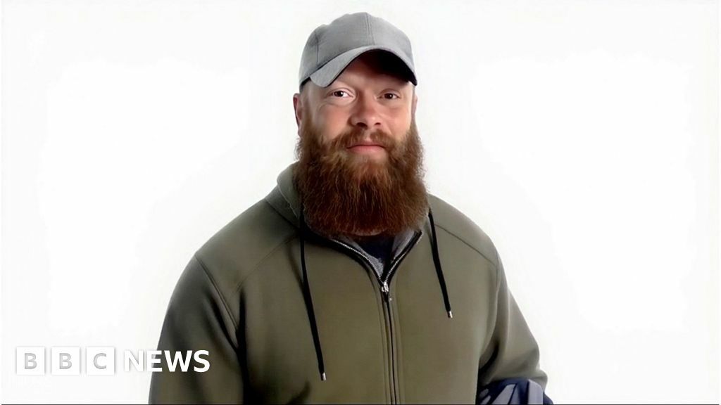 Man in green jacket with baseball hat