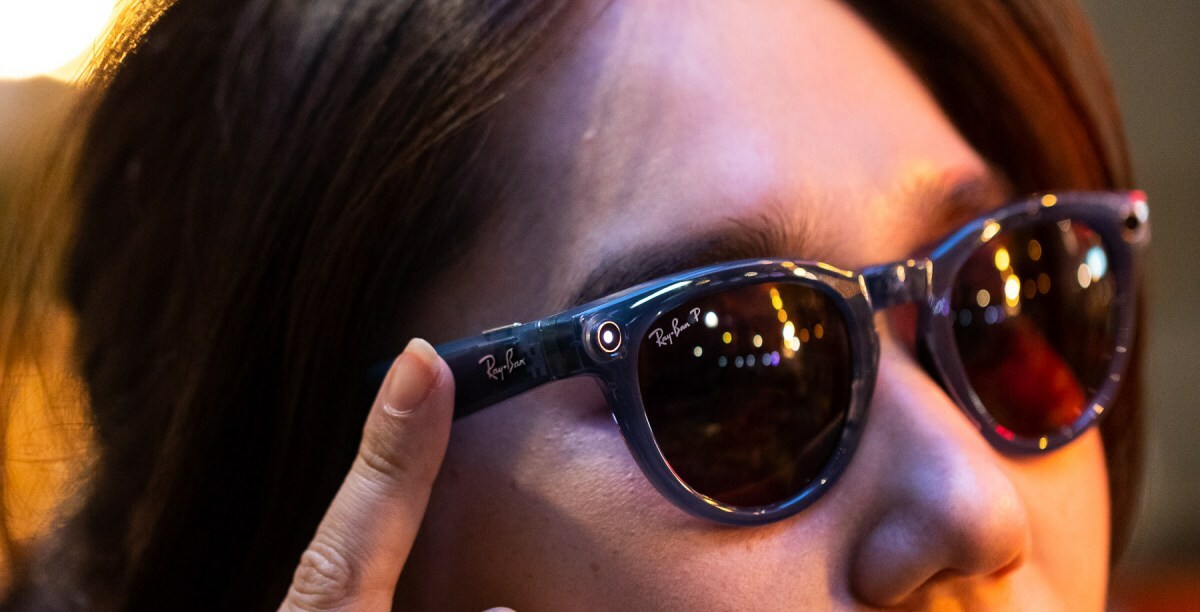 Person tapping side of Ray-Ban Meta smart glasses